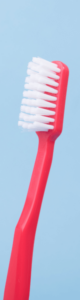 red toothbrush against blue background